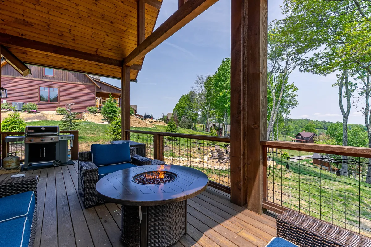 An inviting deck area featuring a fire pit, outdoor seating, a grill, and panoramic views of the surrounding landscape. The image highlights the seamless connection between comfort and adventure, with space for social gatherings and scenic relaxation.