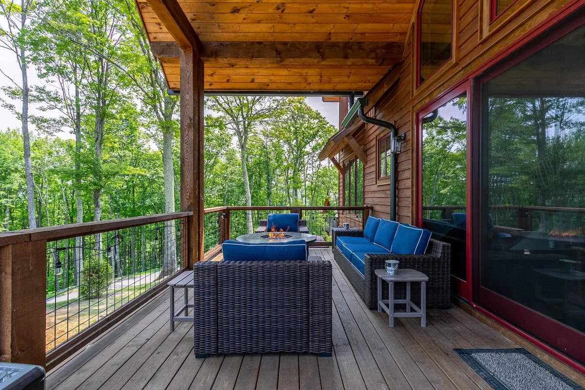 This exterior shot features an inviting outdoor seating area and fire pit, surrounded by trees. The setup is ideal for enjoying nature, relaxing with friends, or spending quality time with pets in a safe, comfortable space.