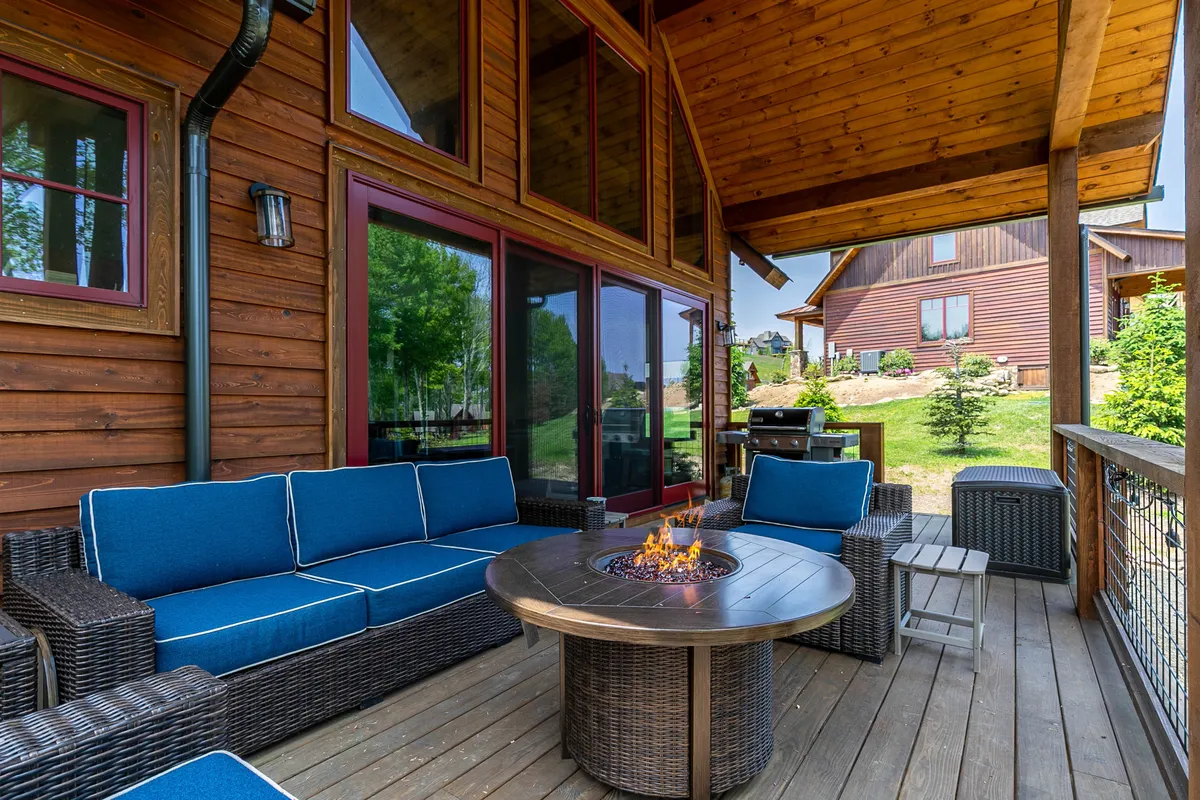 This exterior image showcases a cozy fire pit surrounded by comfortable outdoor seating, set amidst lush greenery. The area is spacious, inviting, and perfect for social gatherings or unwinding after a day out on the trails. The natural setting and open space suggest a welcoming atmosphere for both people and pets.